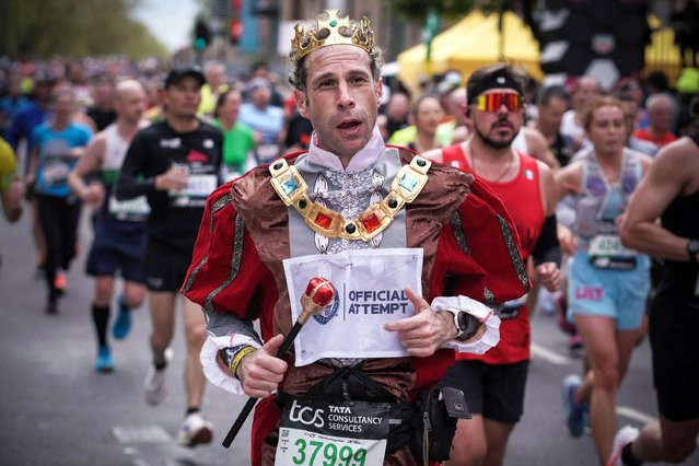 Runner dressed as King Charles in London, UK on April 21, 2024. London Marathon passes down Deptford's Evelyn Street in South East London, the 8 mile mark of the 26.2 mile course where runners are greeted and cheered on by local residents. (Photo by Guy Corbishley/Alamy Live News)