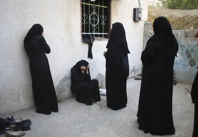 Relatives of Palestinian woman Amani Baraka, whom medics said was killed in an Israeli air strike, mourn during her funeral in Khan Younis in the southern Gaza Strip, in this August 10, 2014 file photo. (Photo by Ibraheem Abu Mustafa/Reuters)