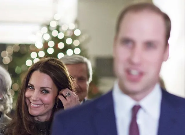 Britain's Catherine, Duchess of Cambridge (L) smiles while she listens to her husband Prince William, Duke of Cambridge as he talks to guests during a reception co-hosted by the Royal Foundation and the Clinton Foundation at British Consul General's Residence in New York, December 8, 2014. (Photo by Eduardo Munoz Alvarez/Reuters)