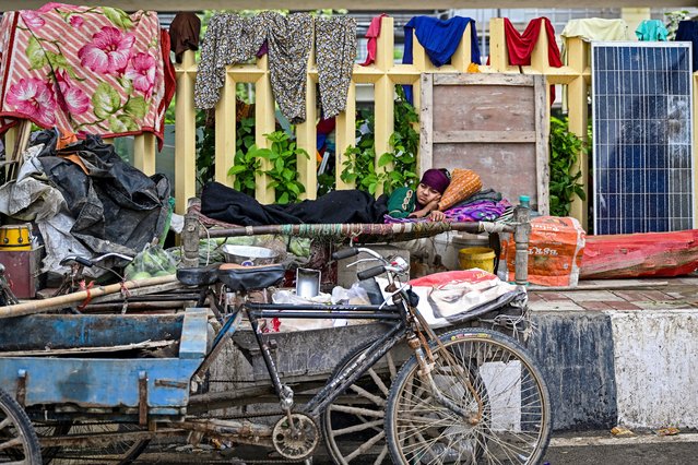A woman takes shelter at a makeshift relief camp beneath a bridge, after heavy rain showers induced a rise in the water level of river Yamuna in New Delhi on September 3, 2025. Northwest India has seen rainfall surge by more than a third on average from June to September, according to the national weather department. In the capital Delhi, relentless rains have swollen the Yamuna river – which breached its danger mark on September 3, inundating several areas and creating traffic snarl-ups lasting for hours. (Photo by Arun Sankar/AFP Photo)