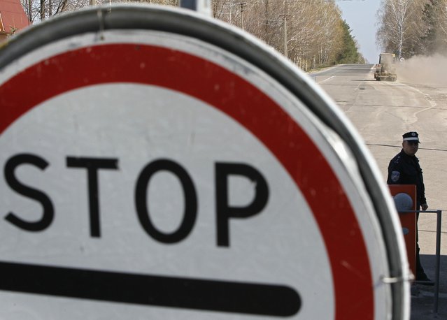 A guard stands at Dityatki checkpoint, marking a 30 km (18-mile) zone around the Chernobyl nuclear power plant April 23, 2013. Ukraine will mark the 27th anniversary of the Chernobyl disaster, the world's worst civil nuclear accident, on April 26. (Photo by Gleb Garanich/Reuters)