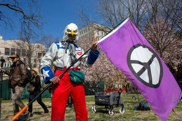A protestor wearing an eagle mask, holds a purple peace flag (Campaign for Nuclear Disarmament) as anti-war activists demonstrate in front of the White House during the National March on Washington on March 18, 2023. (Photo by Probal Rashid/ZUMA Press Wire/Rex Features/Shutterstock)