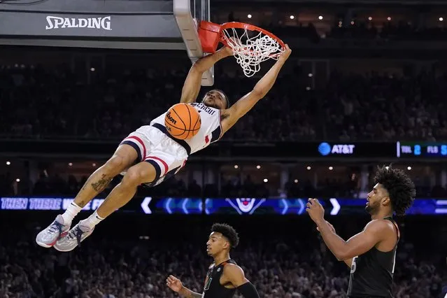 Connecticut guard Andre Jackson Jr. dunks the ball over Miami forward Norchad Omier, right, during the second half of a Final Four college basketball game in the NCAA Tournament on Saturday, April 1, 2023, in Houston. (Photo by David J. Phillip/AP Photo)