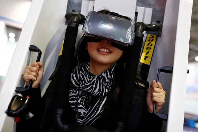 A woman sits in a VR Capsule, a virtual reality simulator, at the WRC 2016 World Robot Conference in Beijing, China, October 21, 2016. (Photo by Thomas Peter/Reuters)