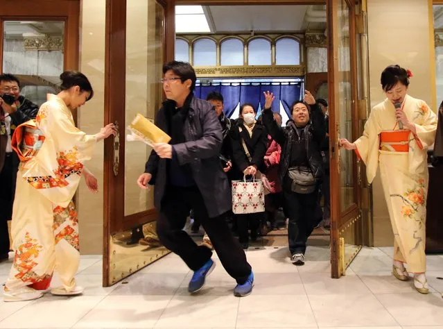 Japanese shoppers rush into a Tokyo department store to buy “lucky bags” containing items worth three times their price tag to celebrate a new year of business in Tokyo on January 2, 2015. Lucky bags are sold each year to celebrate the New Year, Japan's biggest holiday of the year. (Photo by Yoshikazu Tsuno/AFP Photo)