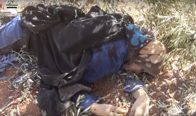 This frame grab from video provided by Muaz al-Shami, Syrian Revolution Network, an opposition activist media organization, that is consistent with independent AP reporting, shows a woman killed after airstrikes killed over 20 people, in the northern rebel-held village of Hass, Syria, Wednesday, October 26, 2016. A team of first responders, the Syrian Civil Defense in Idlib, said at least 50 were wounded in the raids that used parachute mines, targeting the residential area and schools in the village of Hass. Most of those killed were children, the group said on its Facebook page. (Photo by Muaz al-Shami/Syrian Revolution Network via AP Photo)