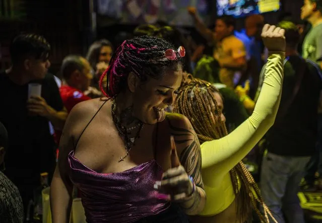 Contestants Meztli Carrasco, front left, and Krishna Torres, dance during the semifinals of the first Miss Colonia pageant hosted by the Factoría nightclub in Veracruz, Mexico, Sunday, March 5, 2023. The nightclub held the pageant as part of annual Women’s Day events and the only requirement for contestants was to prove residency in working-class areas of the city, known as “colonias”. Prizes originally covered utility bills and property taxes, but when the event attracted more sponsors the prizes expanded to include cash, travel, dental work, spas and makeovers. (Photo by Felix Marquez/AP Photo)