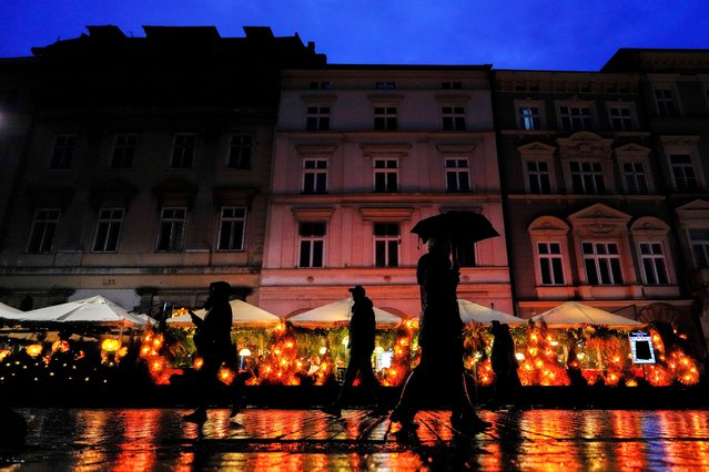 People walk through the main market square in the Old Town neighborhood of Krakow, Poland, November 9, 2025. (Photo by Julia Demaree Nikhinson/AP Photo)
