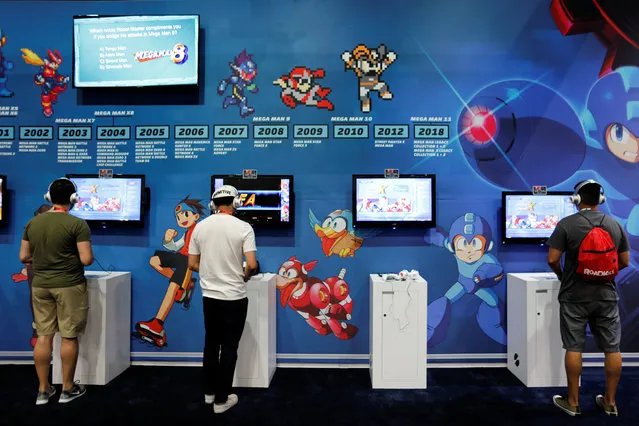 Attendees play video games at E3, the world's largest video game industry convention in Los Angeles, California on June 12, 2018. (Photo by Mike Blake/Reuters)