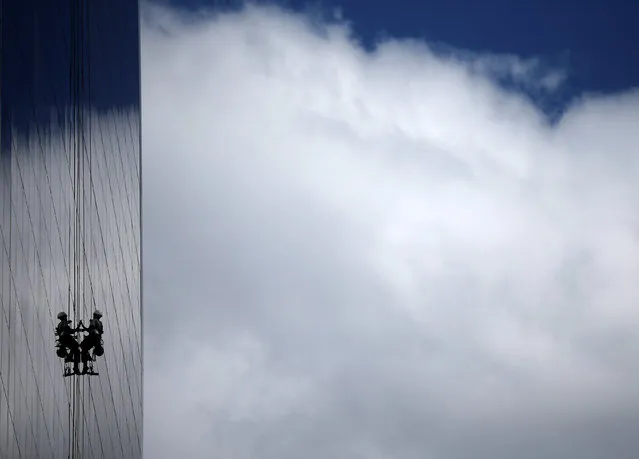 A window cleaner works on the exterior of a hotel outside the 2016 Rio Olympics Park in Rio de Janeiro, Brazil, July 18, 2016. (Photo by Stoyan Nenov/Reuters)