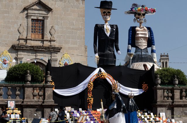 People work on the installation of the 22-meter high “Monumental Catrinas” family, in the main square of Zapotlanejo, state of Jalisco, Mexico, on October 30, 2024. (Photo by Ulises Ruiz/AFP Photo)