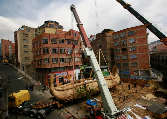 Cranes place “Viracocha III”, a boat made only from totora reeds, on a trailer truck during preparations for the boat to cross the Pacific Ocean, from Chile to Australia on an expected six-month journey, in La Paz, Bolivia, November 8, 2016. (Photo by David Mercado/Reuters)