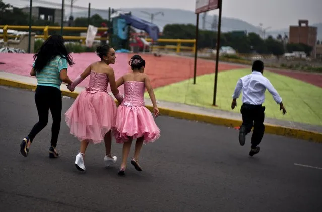 Young students dressed to celebrate their last day of class run across a street in Mexico City, Mexico, Friday, June 29, 2018. Mexicans vote Sunday for positions at every level of government in the country's largest ever elections highlighted by a presidential race led by a slow-speaking leftist cast as genuine change. (Photo by Ramon Espinosa/AP Photo)