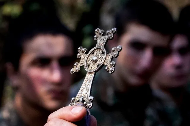 Servicemen take part in a christening service performed near the front line in Nagorno-Karabakh on November 2, 2020. The fighting between Armenia and Azerbaijan over Nagorno-Karabakh resumed in late September, with both countries blaming each other for provocation, declaring martial law, and mobilising their armed forces. (Photo by Stanislav Krasilnikov/TASS)