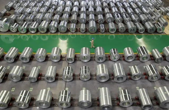 An employee walks past columns of steel as she works at a steel production factory in Wuhan, Hubei province, in this August 2, 2012 file photo. China is expected to release commodities output data for 2015 this week. (Photo by Reuters/Stringer)