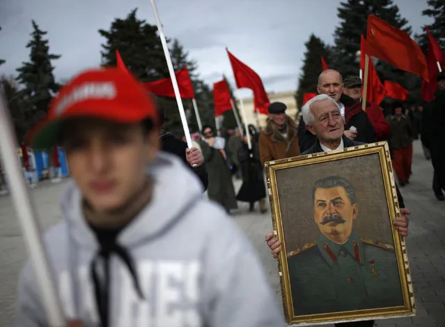 People carry flags and a portrait of Soviet leader Joseph Stalin while marching during a rally to mark Stalin's birthday anniversary at his hometown in Gori, Georgia, December 21, 2015. (Photo by David Mdzinarishvili/Reuters)