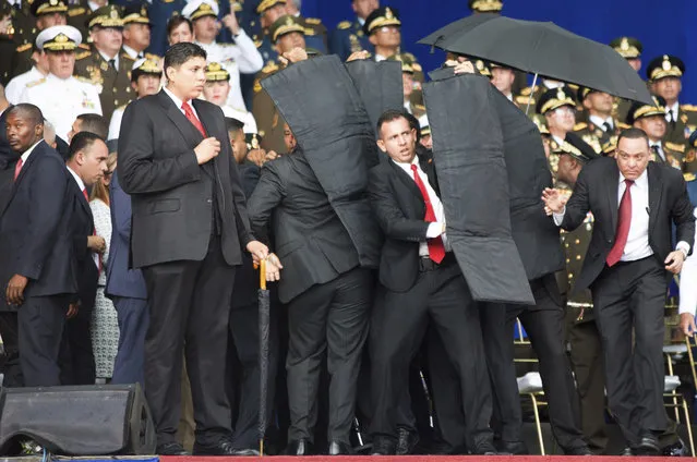 In this photo released by China's Xinhua News Agency, security personnel surround Venezuela's President Nicolas Maduro during an incident as he was giving a speech in Caracas, Venezuela, Saturday, August 4, 2018. Drones armed with explosives detonated near Venezuelan President Nicolas Maduro as he gave a speech to hundreds of soldiers in Caracas on Saturday but the socialist leader was unharmed, according to the government. (Photo by Xinhua News Agency via AP Photo)