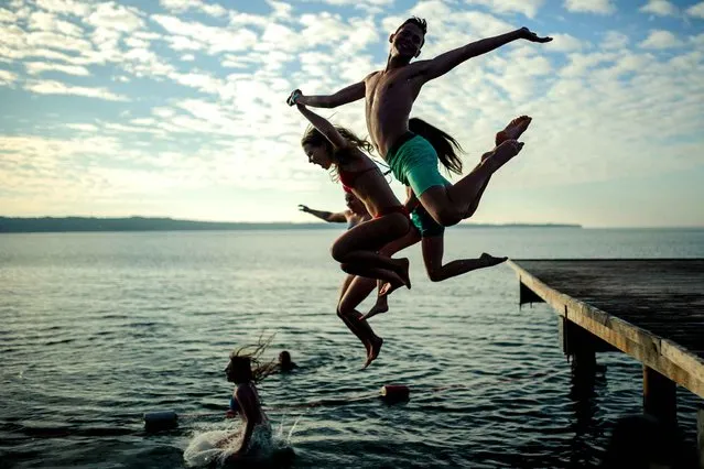 Young people plunge during the traditional New Year's jump into the Adriatic sea in Portoroz, on January 1, 2016. (Photo by Jure Makovec/AFP Photo)