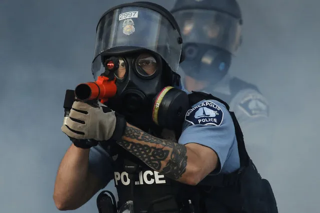 In this image released by World Press Photo, Thursday April 15, 2021, by John Minchillo, Associated Press, part of a series titled Minneapolis Unrest: The George Floyd Aftermath, which won third prize in the Spot News Stories category, shows Police fire tear gas on demonstrators at the intersection of East Lake Street and Hiawatha Avenue in St Paul, Minnesota, USA, on May 29, 2020, near the precinct station of the officers who arrested George Floyd. (Photo by John Minchillo, Associated Press, World Press Photo via AP Photo)