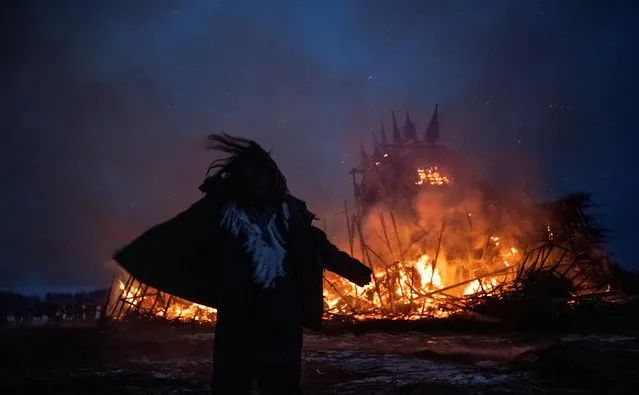 Young woman dances in front of a burning installation called “Vaccination Tower”, during celebrations of Maslenitsa, a pagan holiday, marking the end of the winter in the village of Nikola Lenivets in Kaluga region, Russia on March 13, 2021. (Photo by Maxim Shemetov/Reuters)
