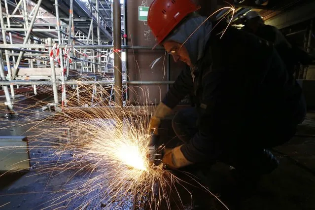 A ship builder works on a section of the Oasis Class 3 cruise ship under construction at the STX Les Chantiers de l'Atlantique shipyard site in Saint-Nazaire, western France, February 17, 2015. (Photo by Stephane Mahe/Reuters)