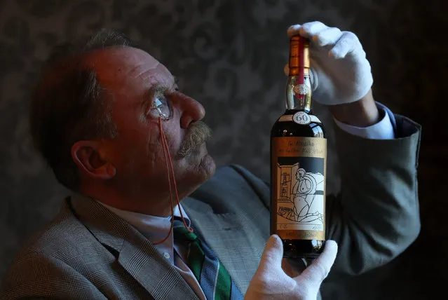 Whisky expert Charles MacLean with the world's rarest and most valuable whisky – a bottle of The Macallan Valerio Adami 60 year-old 1926 with an estimate of £700,000-900,000 – ahead of the Bonhams upcoming Whisky Sale at their Edinburgh auction house on Monday, September 24, 2018. (Photo by Andrew Milligan/PA Wire)