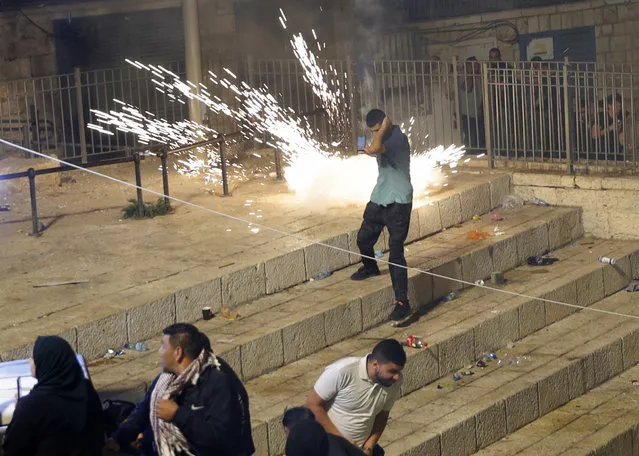 Palestinians run from stun grenades fired by Israeli police officers during clashes at Damascus Gate just outside Jerusalem's Old City, Saturday, May 8, 2021. (Photo by Oded Balilty/AP Photo)