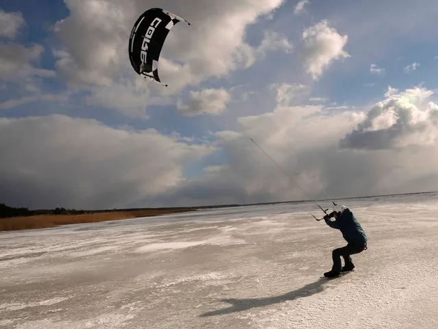 A man kite-skates on ice at the sea near Svetciems, Latvia on March 19, 2021. (Photo by Ints Kalnins/Reuters)