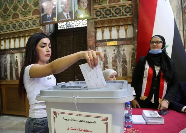 A woman casts her vote at a polling station during the presidential elections, in Damascus, Syria on May 26, 2021. (Photo by Yamam al Shaar/Reuters)