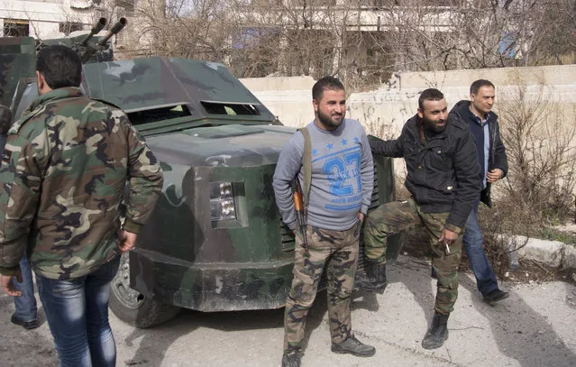 Syrian soldiers pose for the foreign media beside a pickup truck with a gun mounted on top in Salma, Syria, Friday, January 22, 2016. Syrian government forces relying on Russian air cover have recently seized Salma, located in Syria's province of Lattakia, from militants. The Syrian government offensive has given Assad a stronger hand going into peace talks with the opposition that are planned for next week in Switzerland. (Photo by Vladimir Isachenkov/AP Photo)