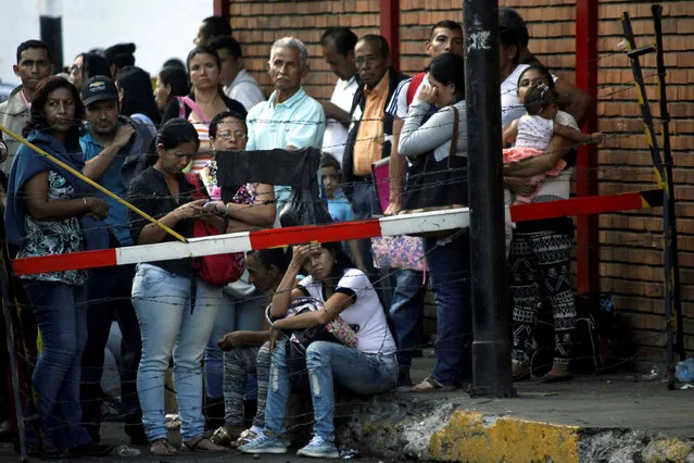 People wait next to fences to try to cross the Simon Bolivar international bridge into Colombia, in San Antonio del Tachira, Venezuela December 13, 2016. (Photo by Carlos Eduardo Ramirez/Reuters)