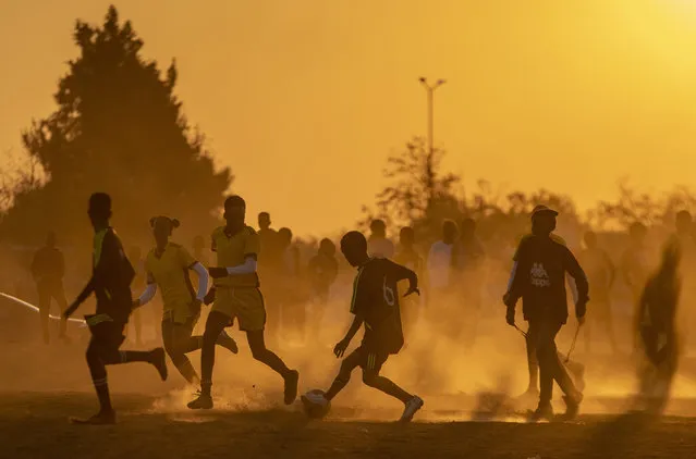 Soccer players play a friendly match on a dusty soccer field in Soweto, South Africa, Wednesday, June 16, 2021. (Photo by Themba Hadebe/AP Photo)