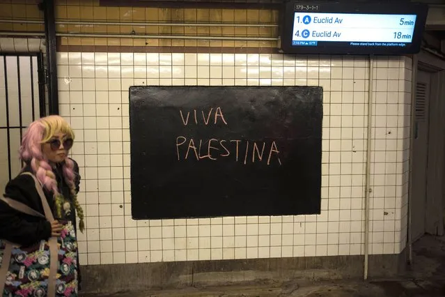 A woman walks next to graffiti reading in Spanish “Long Live Palestine”, in a subway station in the Brooklyn borough of New York, Sunday, October 15, 2023. (Photo by Rodrigo Abd/AP Photo)