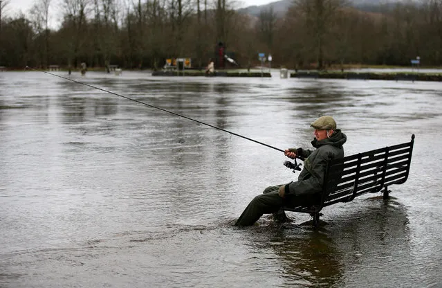 Andy Casey from Clydebank fishes from a flooded bench by the river Teith in Callander, Scotland on January 31, 2016. (Photo by Andrew Milligan/PA Wire)