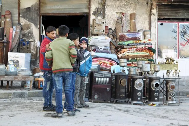 Boys stand near goods displayed for sale in Aleppo's eastern district of Tariq al-Bab, Syria January 19, 2016. (Photo by Abdelrahmin Ismail/Reuters)