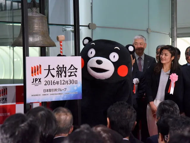 Kumamon (C), the black bear mascot of Japan's southwestern Kumamoto Prefecture, rings the bell during a ceremony marking the final trading day of the year at the Tokyo Stock Exchange on December 30, 2016. Four-time reigning Olympic wrestling champion Kaori Icho can be seen to the right. The Nikkei stock index finished at 19,114.37, the highest close in 20 years for the final trading day of the year. (Photo by Satoko Kawasaki/Kyodo News)