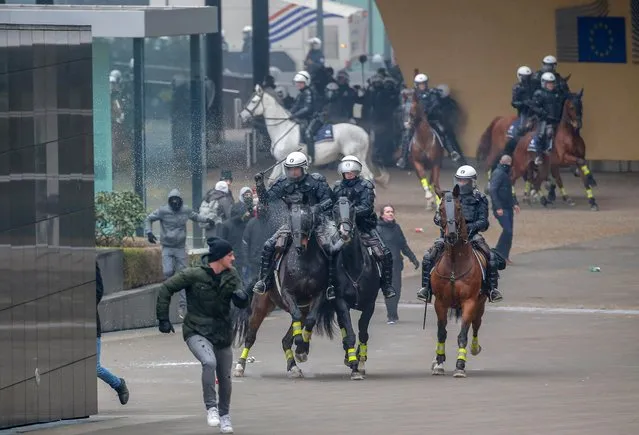 Mounted police officers chase protesters of right-wing and far-right Flemish associations during the “March Against Marrakech” demonstration near European institutions headquarters in Brussels, Belgium, 16 December 2018. Anti-immigration protesters took to the streets of Brussels to denounce the Global Compact on Migration adopted in Marrakesh and approved by the Belgian Prime Minister. The march was organized by several right-wing and far-right Flemish associations such as KVHV, NSV, Schild & Vrienden, Voorpost and Vlaams Belang Jongeren. (Photo by Julien Warnand/EPA/EFE)