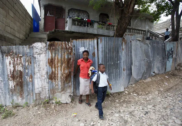In this January 10, 2017 photo, Nerlande Jean Philippe escorts her son Judeley Hans Debel, who walks on a prosthetic right leg, to his transportation to school in Petion-Ville, Haiti. Judeley's unemployed mother says free weekly sessions of therapeutic horse riding offer her son a welcome respite from a life of urban poverty. (Photo by Dieu Nalio Chery/AP Photo)