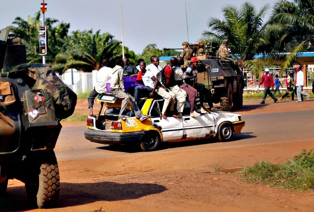 A packed taxi drives past a French checkpoint in Bangui, Central African Republic, Monday December 16, 2013. Over 1600 French troops have been deployed to the country in an effort to put an end to sectarian violence.  More than 600 people have been killed since Anti-Balaka launched a strike over Bangui last week before being pushed back. (Photo by Jerome Delay/AP Photo)