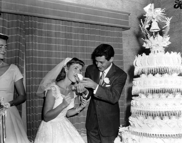Singer Eddie Fisher, 26, feeds a piece of wedding cake to his bride, actress Debbie Reynolds, 23, following their marriage at Grossinger, N.Y., on September 26, 1955. (Photo by Marty Lederhandler/AP Photo)
