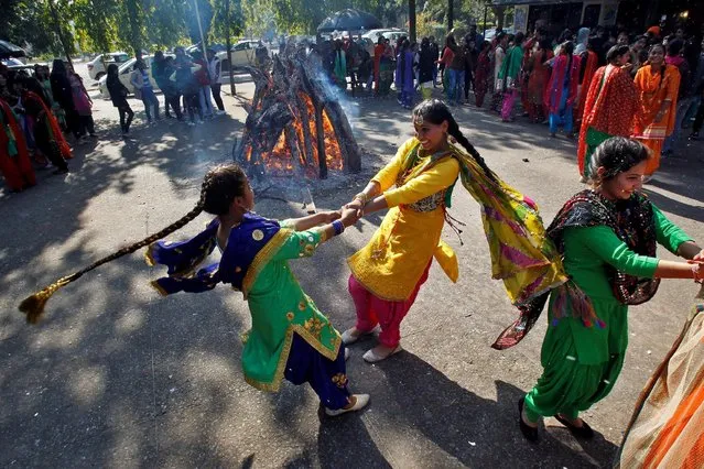 Students perform a traditional folk dance near a bonfire as they celebrate the Lohri festival, which marks the culmination of winter in many parts of northern India, inside a college in Chandigarh, India, January 13, 2017. (Photo by Ajay Verma/Reuters)
