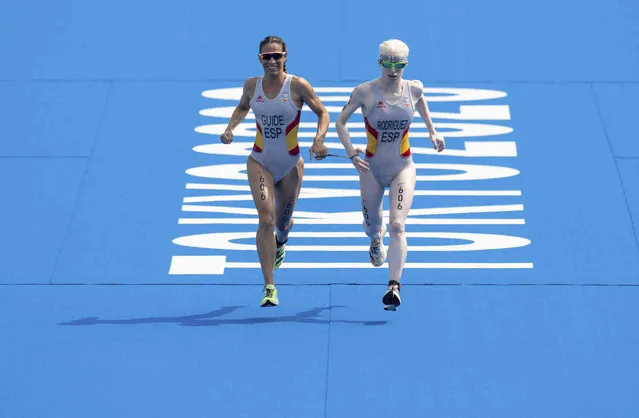 Susana Rodriguez, right, of Spain, and her guide Sara Loehr, left, also of Spain, approach the line to take the gold medal in the women's triathlon PTV1 at Odaiba Marine Park during the Tokyo 2020 Paralympic Games on Saturday, August 28, 2021, in Tokyo. (Photo by Joe Toth for OIS via AP Photo)