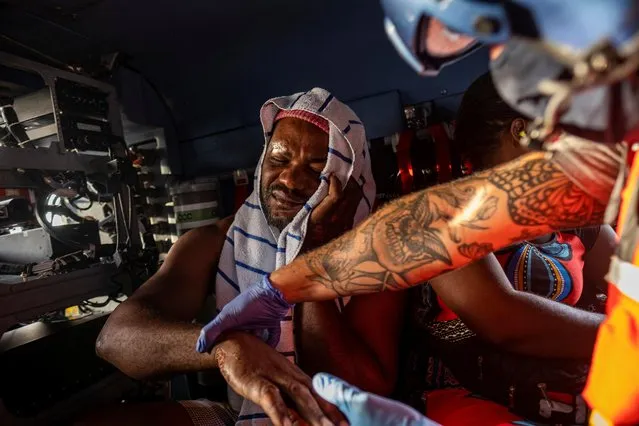 A U.S. Coast Guard flight crew member checks a patient during a medevac mission to Port-au-Prince of patients injured during the 7.2 magnitude quake, in Les Cayes, Haiti on August 21, 2021. (Photo by Ricardo Arduengo/Reuters)