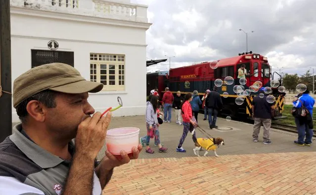 A street vendor blows bubbles as a “La Sabana” tourist train makes a stop in Zipaquira city March 1, 2015. (Photo by Jose Miguel Gomez/Reuters)