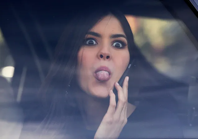 Miss Universe Paulina Vega, from Colombia, jokingly sticks her tongue out at photographers from a car after visiting patients at a military hospital in Bogota, Colombia, Tuesday, April 28, 2015. Vega is in her native country for her first official visit since she was crowned Miss Universe in January. (Photo by Fernando Vergara/AP Photo)