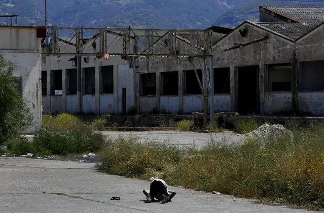A Sudanese immigrant prays at an abandoned factory in the western Greek town of Patras May 4, 2015. (Photo by Yannis Behrakis/Reuters)