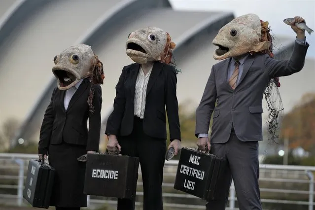 Campaigners from the environment group Ocean Rebellion wearing fish head masks take part in a protest stunt against the Marine Stewardship Council (MSC), on the fringes of the COP26 U.N. Climate Summit taking place in Glasgow, Scotland, Thursday, November 4, 2021. (Photo by Alastair Grant/AP Photo)
