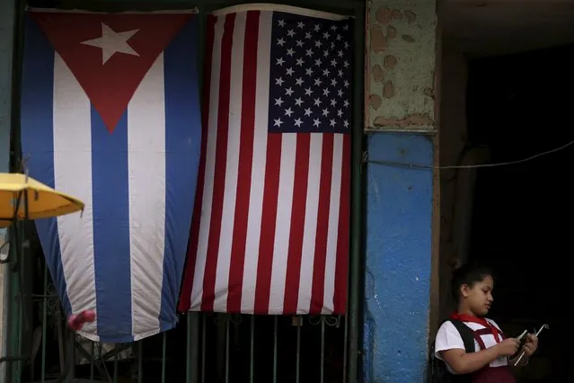 A child is seen in front of a house adorned with flags of U.S. and Cuba on the outskirts of Havana, Cuba March 21, 2016. (Photo by Ueslei Marcelino/Reuters)