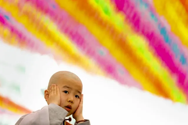 A novice monk gestures during prayer at an inauguration ceremony at Jogye temple in Seoul, May 11, 2015. (Photo by Thomas Peter/Reuters)