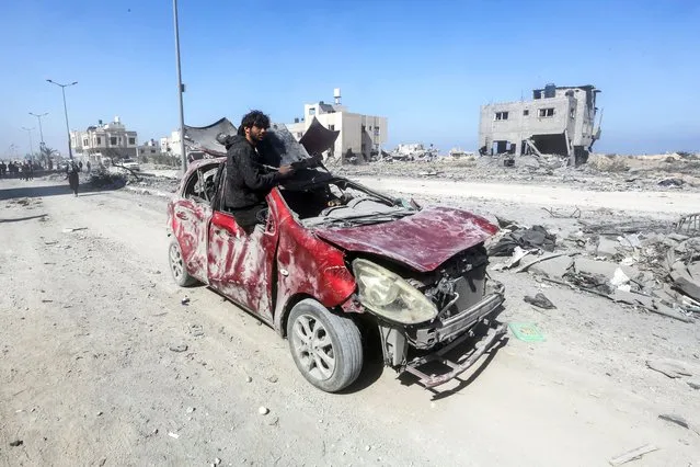 A Palestinian man rides in a damaged car as he tours Qatari-funded Hamad City following an Israeli raid, amid the ongoing conflict between Israel and Hamas, in Khan Younis in the southern Gaza Strip on March 13, 2024. (Photo by Ahmed Zakot/Reuters)